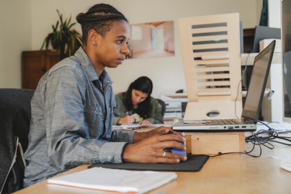 Najat Croll works at her computer at the company’s headquarters in Essex Junction. As New Frameworks has grown and evolved over 17 years, a focus on inclusivity and low-impact homes has remained core to the company’s values. Photo by Erica Houskeeper.